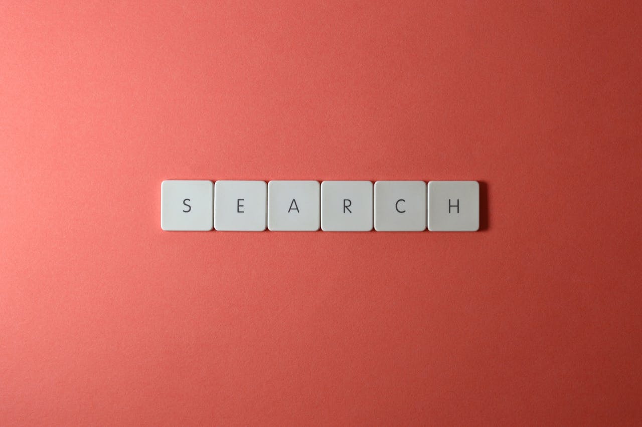 White keyboard keys spelling search on a bold red surface, conceptual design with copyspace.
